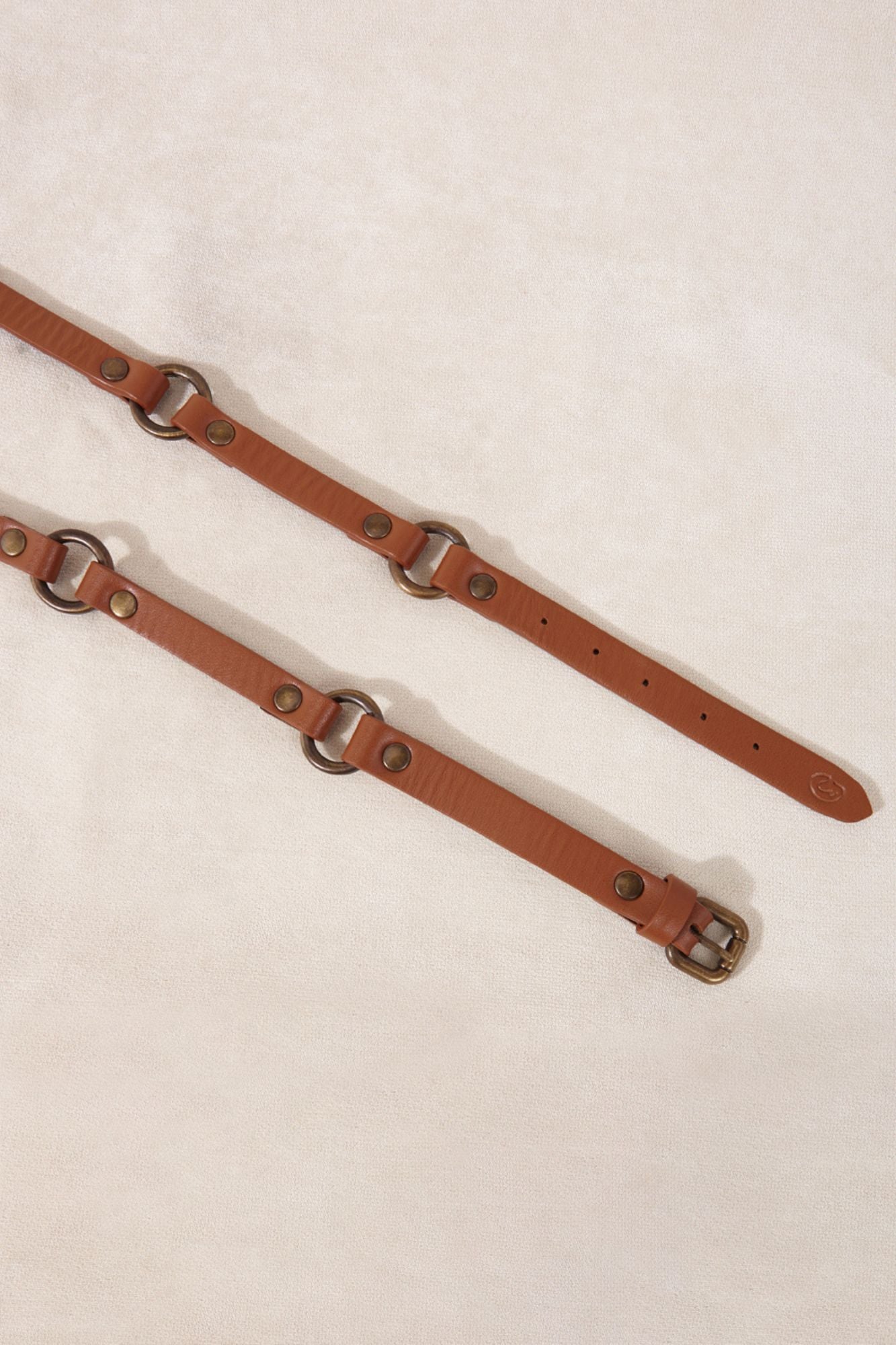 Cinturón de piel color marrón con hebillas metálicas