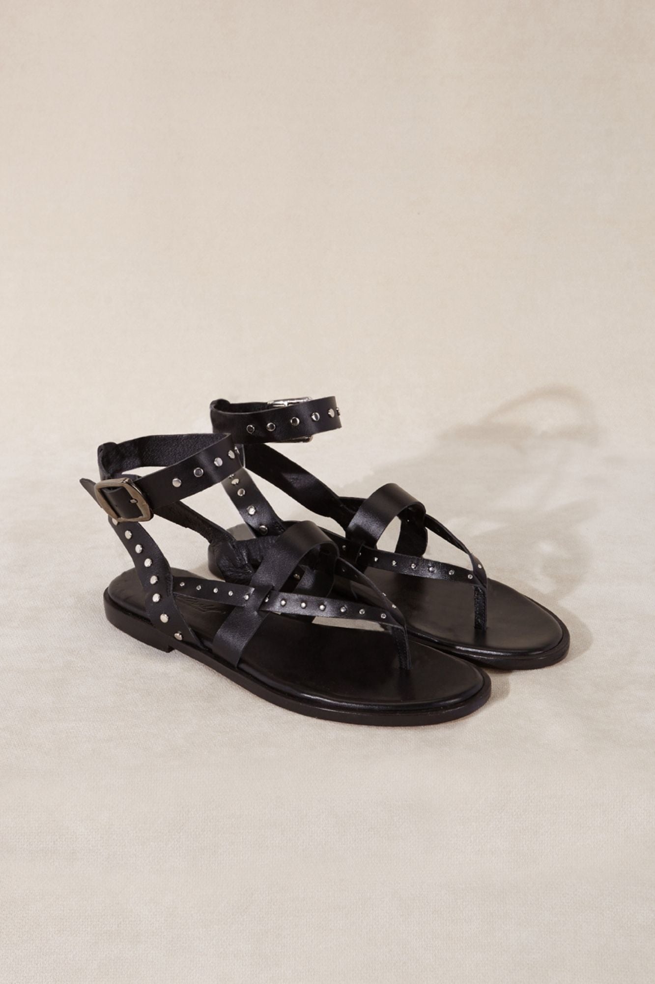 Sandalia de piel color negro con detalles metálicos y correas tobilleras hecho en España